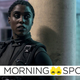 Lashana Lynch wears all black tactical gear and stands against a concrete pillar as 007 in No Time to Die.